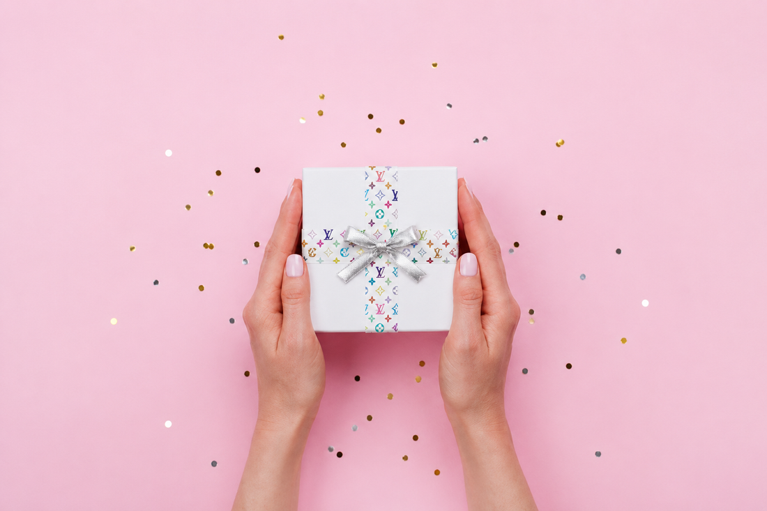 White gift box decorated with designer washi tape used as ribbon and a silver bow