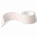 A roll of washi tape with a repeating pastel pattern of 'G' letters and polka dots on a white background, shown with one end unrolled.
